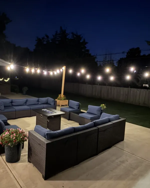 Backyard patio string lights on custom cedar posts at night