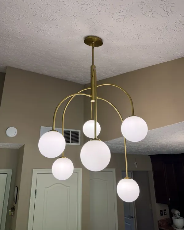 Brass globe chandelier installation