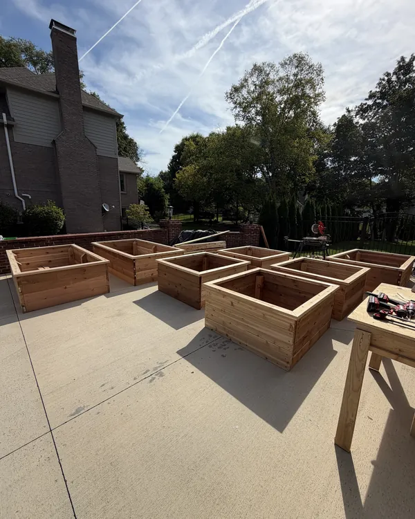 A set of cedar raised garden beds built on a driveway