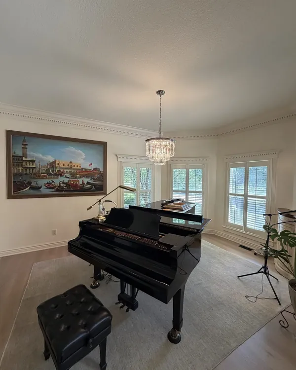 Drum shade chandelier installed in a grand piano room