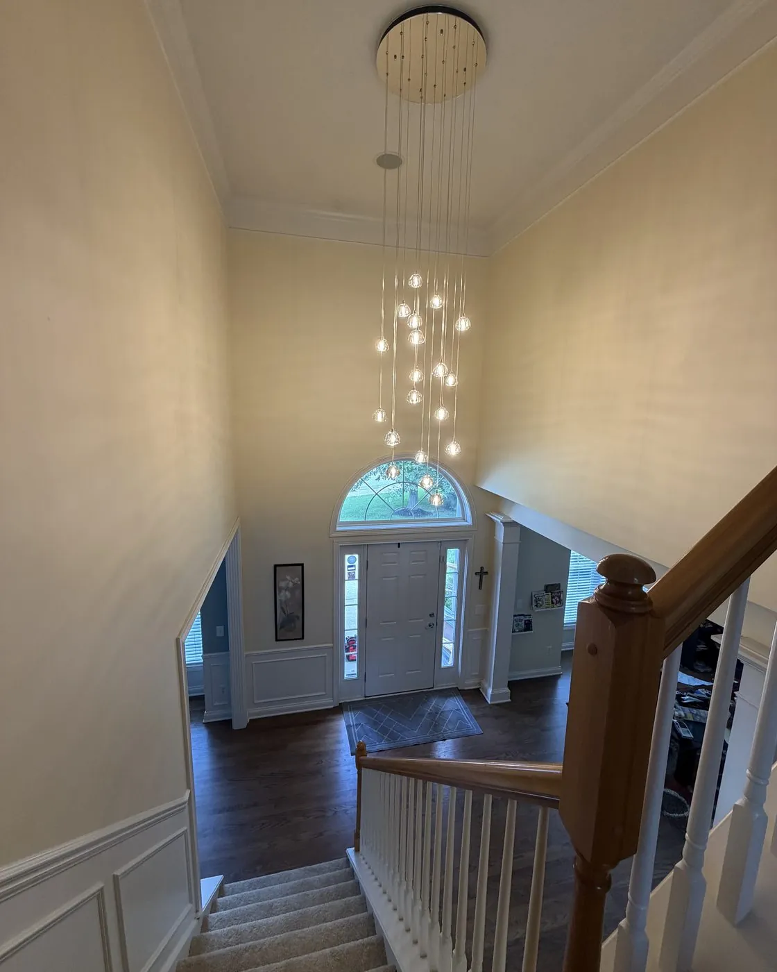 Cascading pendant chandelier installed in a two-story stairwell